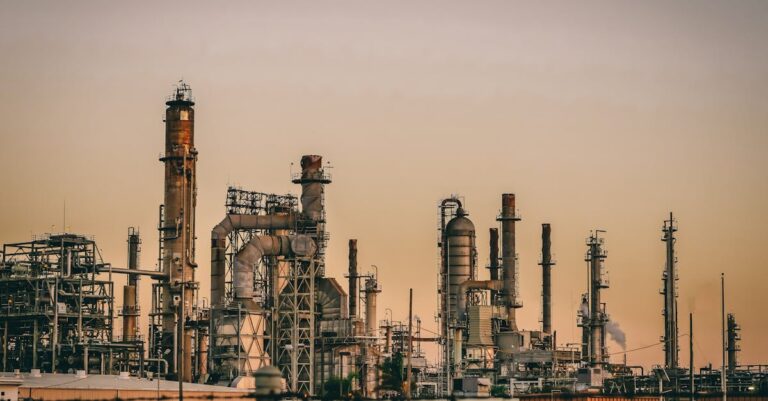 A large industrial power plant silhouetted against the warm hues of a sunset.