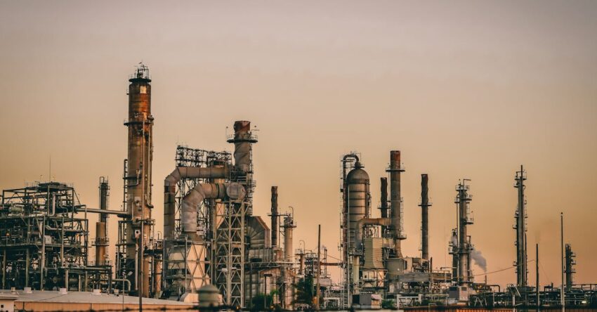 A large industrial power plant silhouetted against the warm hues of a sunset.